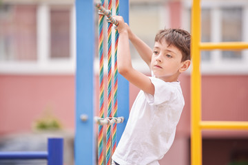 Obraz premium The boy plays on the stairs at the children's playground.