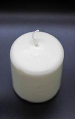 White wax candle. Black background. Wax candle closeup 