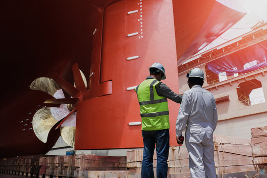 workers at dry dock in shipyard during Underside of ship