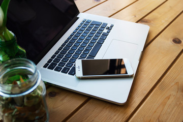 窓辺リビングのノートパソコンとスマートフォン