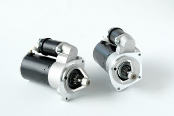 Spare parts for passenger cars. Close-up of two new car starters on a white background, top view.