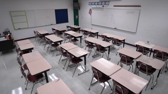 Wide-angle steadicam motion turning showing an empty school classroom.