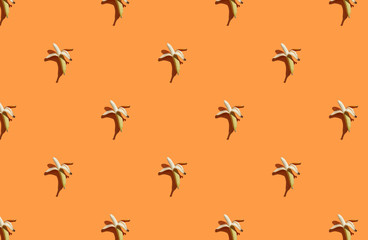 Trendy sunlight Summer pattern made with banana on bright light orange background