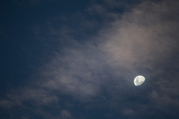 Naklejka na ściany i meble Lua entre nuvens no entardecer