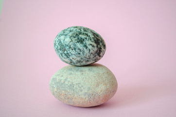 Fototapeta na wymiar Elegant balanced stones in the center of a beauty pink background