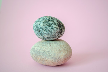 Elegant balanced stones in the center of a beauty pink background