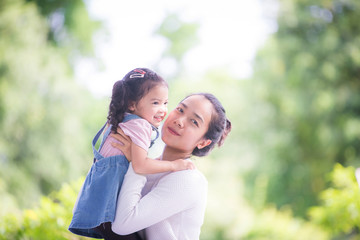 Portrait of happy loving mother and her baby outdoors, Asian girl lifestyle. Asia mother's day concept