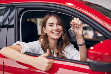 Happy woman with key of new car