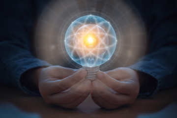 Hand of engineer holding illuminated light bulb, innovation technology, inspiration, new ideas and creativity concept.