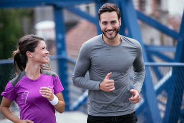 Athletic couple jogging in the city. Happy couple training outdoors.