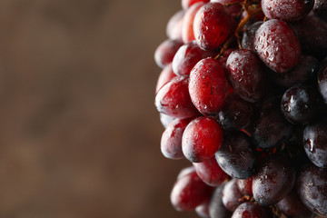 Ripe grape on brown background, space for text