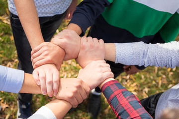A friendly gesture handshake. The joined hands form a circle or hexagon. Meeting or saying goodbye to six young guys.
