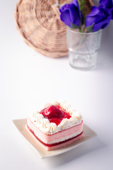 Strawberry layer cake in ceramic plate on white background