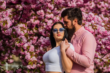 Fashionable couple on spring background. Couple in love enjoying pink cherry blossom. Man and woman in blooming garden. Happy easter. couple in love sakura blossom. man and woman in cherry bloom