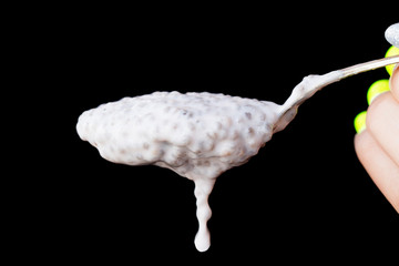 Dietary Homemade Natural Breakfast With Fresh Organic Ingredients yogurt and chia seeds in spoon on black background. Close up.