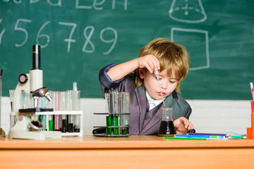 Little kid learning chemistry in school laboratory. Biology school laboratory equipment. little boy at lesson. Back to school. Little boy at the elementary school. Home schooling