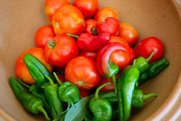 Tomates y pimientos en un recipiente de cerámica
