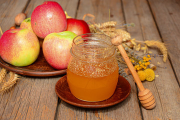 Jars of honey with apples on wooden table. Harvest of ripe apples and honey. Church celebration of the apple feast day. harvest concept