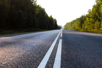 Fototapeta premium Photo of an asphalt road with markings. Summer, forest. The concept of travel, transportation, moving, vacation.