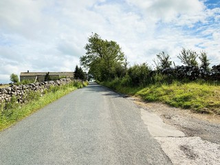 Country road, with dry stone walls, leading over the top of the hill into, Kirby Malham, Skipton, UK