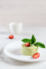 Avocado panna cotta with strawberries and mint on a white plate. Sugar, lactose, gluten free. Healthy food, diet, vegetarian.