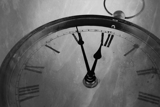Retro black and white clock with five minutes before twelve