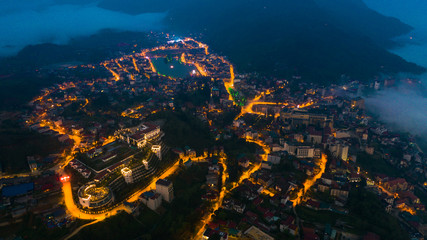 Aerial view of panorama landscape at the hill town in Sapa city, Vietnam at night and sunset, mountain view in the clouds