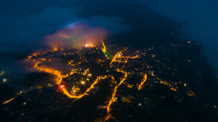 Aerial view of panorama landscape at the hill town in Sapa city, Vietnam at night and sunset, mountain view in the clouds