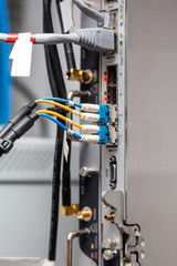 Fiber optic cables are connected to radio relay equipment. Close-up. Vertical orientation. 