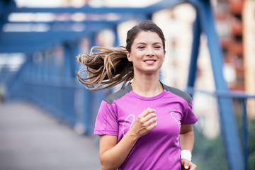 Happy athletic woman running in nature in the morning. Young woman training outdoors..