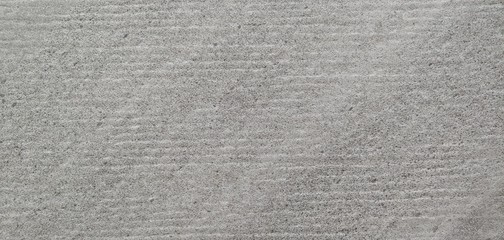 a gray wall with small horizontal lines visible_background