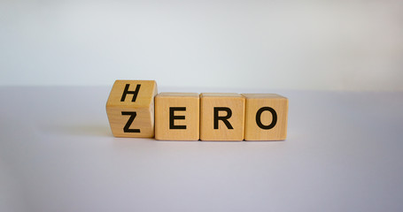 From zero to hero concept. Hand turns a cube and changes the word 'zero' to 'hero'. Beautiful white...