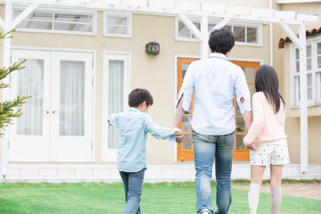 Fototapeta premium 庭を歩く親子の後ろ姿