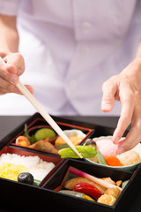 懐石弁当の盛り付けをする手元