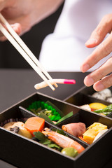 懐石弁当の盛り付けをする手元