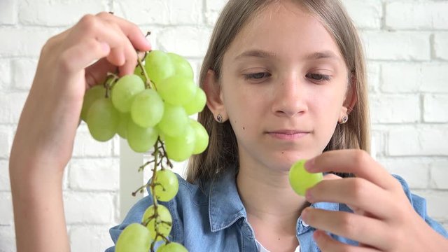 Kid Eating Grapes, Child Eats Fresh Fruits, Young Teenager Girl at Breakfast in Kitchen