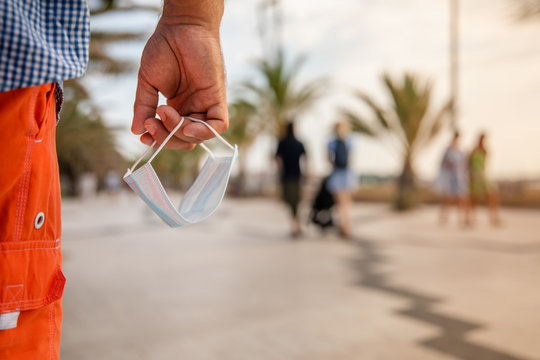 A guy holding a facemask and ready to protect himself
