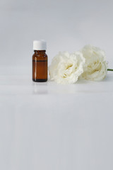 Fototapeta na wymiar Eustoma extract (remedy) bottle with fresh Eustoma flower isolated white