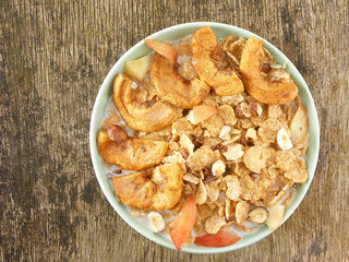 Plate of granola with milk on a wooden surface
