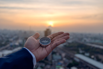 Businessman holding a navigation compass in hand and define marketing direction, Abstract business