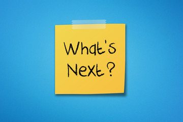 Yellow sticky note paper with what's next on blue background	