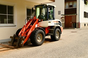 Tractor with equipment is in the farm yard.