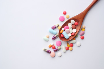 high angle view of pills and capsule on spoon on white background 