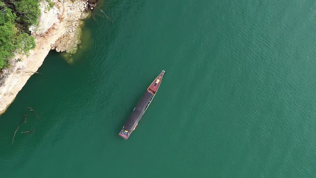 Aerial view drone video of girl relaxing on boat in beautiful lake and mountain