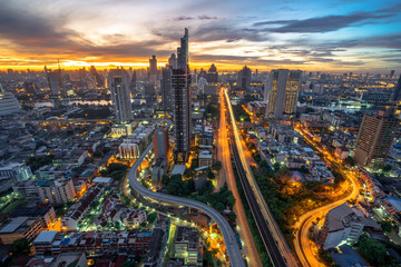High angle of Bangkok and skyscrapers with light trails on Sathorn Road at sunrise, Taksin Bridge across the Chao Phraya River, Bangkok, Thailand, Jul 17, 2020.