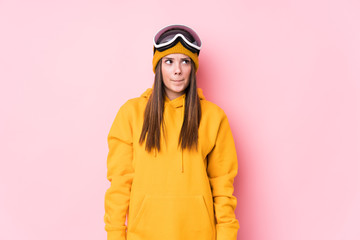 Young caucasian skier woman isolated confused, feels doubtful and unsure.