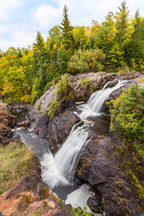 Gabbro Falls, a beautiful tiered waterfall on the Black River in Upper Peninsula Michigan, cascades in an early autumn scenic landscape.