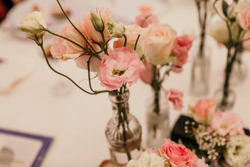 Small arrangements of white and pink flowers were displayed in vintage glass bottles