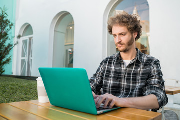Young man using his laptop in a coffee shop.