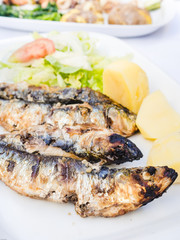 Traditional Portuguese dish of grilled sardines with potatoes.